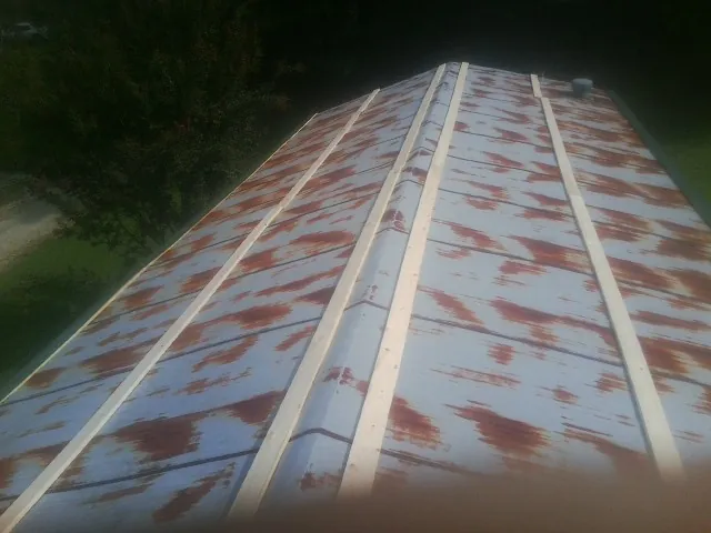 Rusted metal roof panels with new wood purlins before replacement — Storm Damage Roof Repair in Carriere by Roofing Brothers