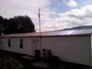 New metal roof on a single wide mobile home with a TV antenna in Carriere