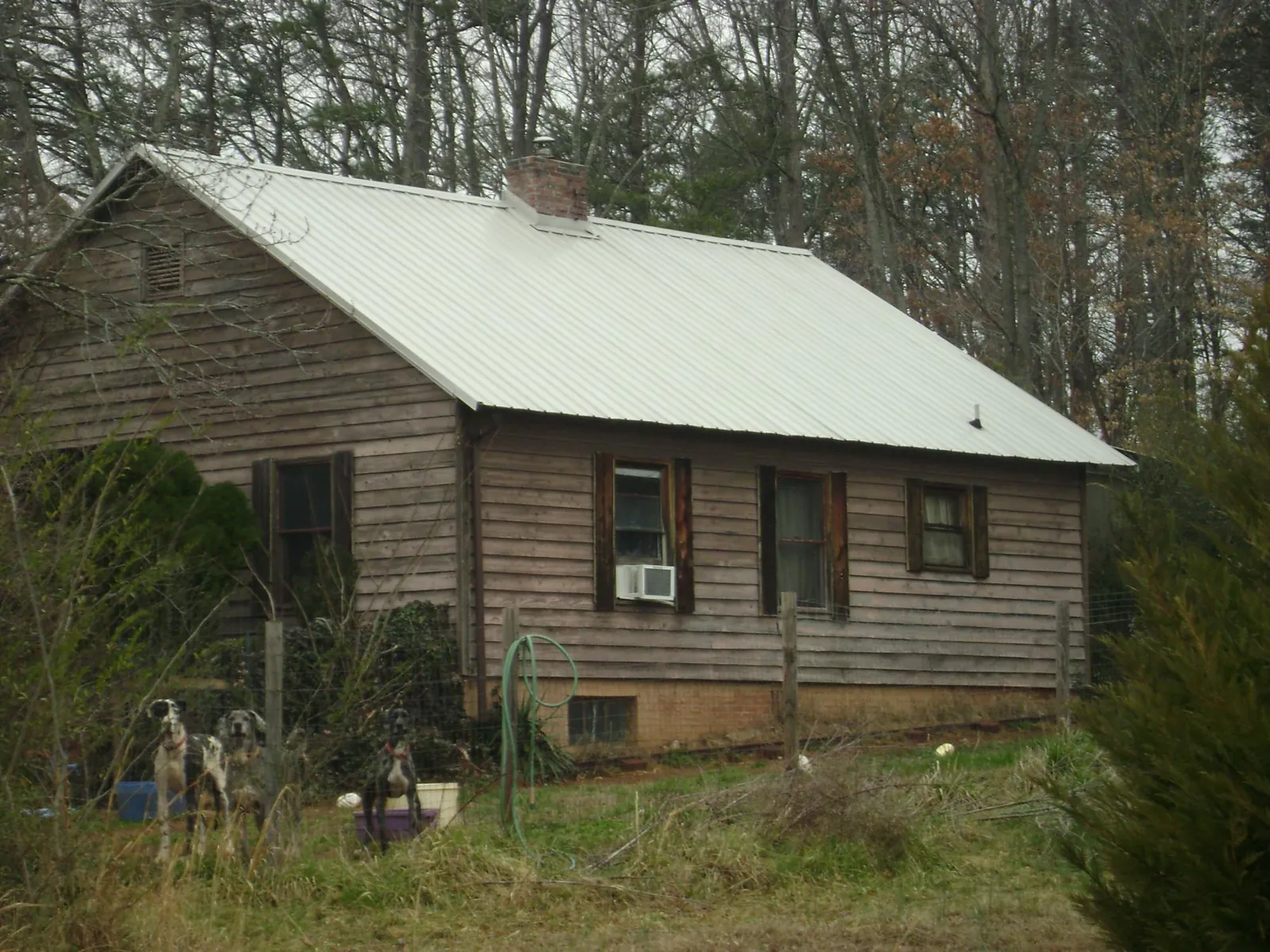 White metal roof on an old wood sided farmhouse, from a Metal Roof Installation job in Carriere